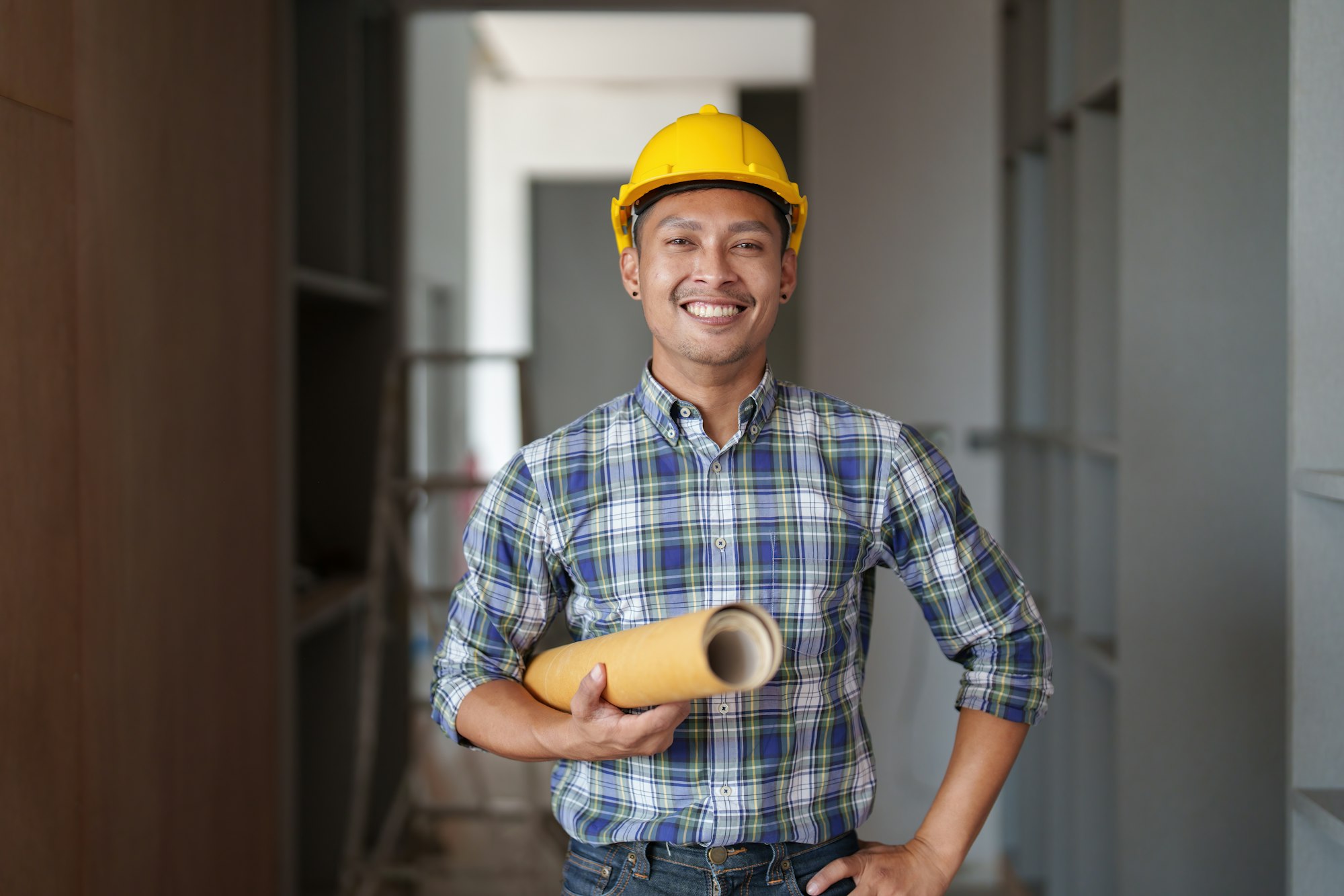 Architect man working with blueprints for architectural plan, engineer sketching a construction