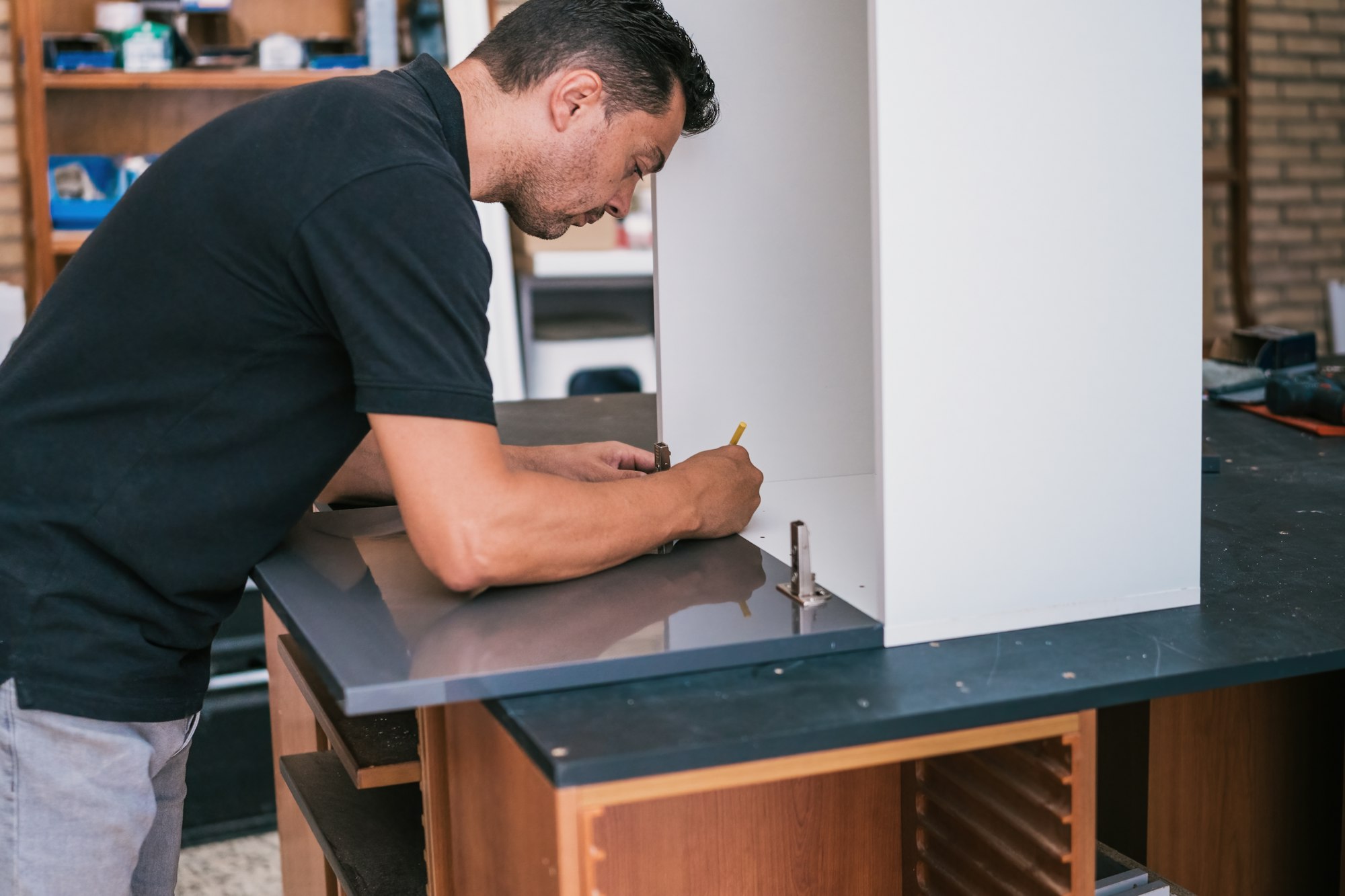 Man marking the surface of a kitchen that are constructing