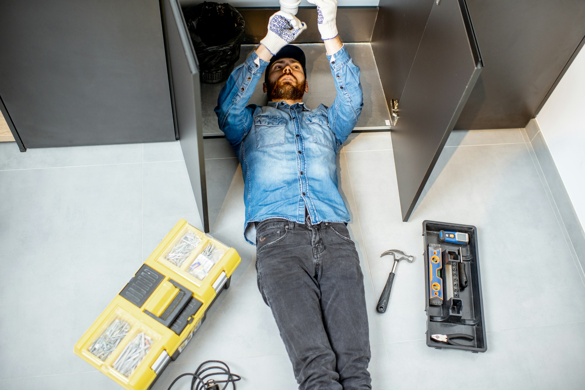 Man repairing kitchen plumbing