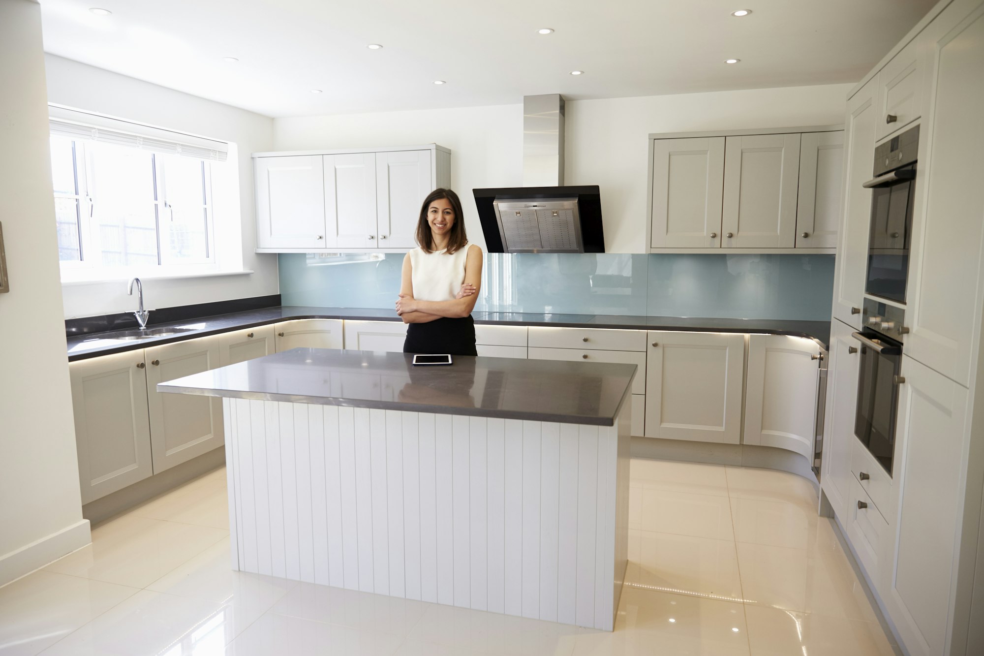 Portrait Of Female Realtor In Kitchen Valuing House