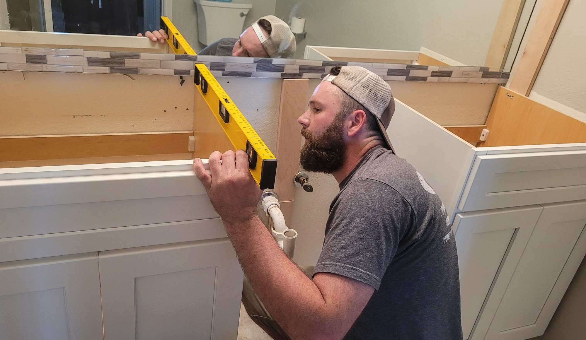 Remodeling specialist making sure the cabinets are installed properly in bathroom.